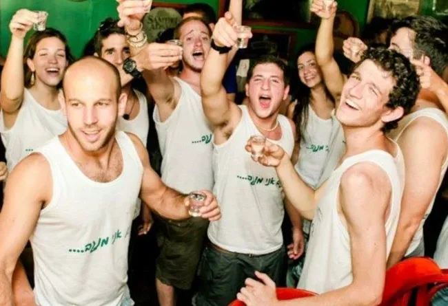 עובדים מחייכים בחומוס הבוטקה ומרימים שוט