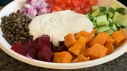 צלחת עם חומוס, סלק, עדשים, בטטה, ירקות קצוצים ויוגורט. מנה צבעונית וטעימה מחומוס הבוטקה.
