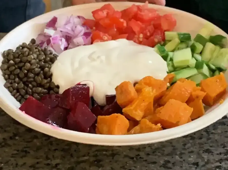 צלחת עם חומוס, סלק, עדשים, בטטה, ירקות קצוצים ויוגורט. מנה צבעונית וטעימה מחומוס הבוטקה.